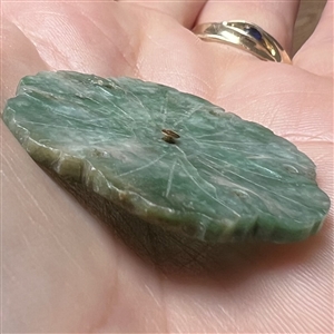 Carved jade button of a realistic flower.