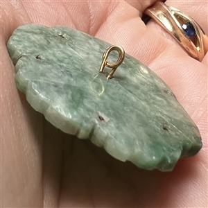 Carved jade button of a realistic flower.