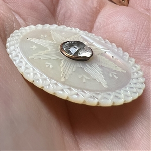 An 18th c. carved mother of pearl button with faceted paste center.