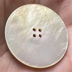 Transfer on iridescent shell button of two children on a swing.