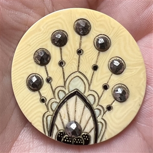 Celluloid button with facetted steels.