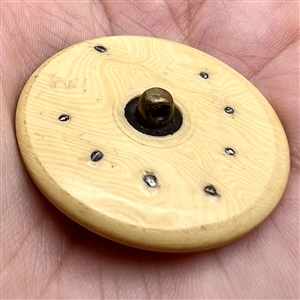 Celluloid button with facetted steels.