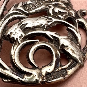 Hallmarked openwork silver button of a plant (thistle?).