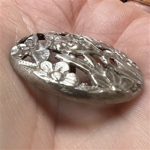 Hallmarked openwork silver button of a fairy face in garden.