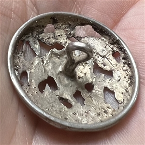 Hallmarked openwork silver button of a fairy face in garden.