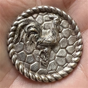 White metal button of a rooster.