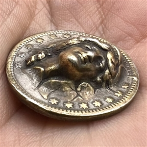 Coin-type metal button of lady liberty. 