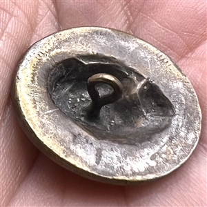 Coin-type metal button of lady liberty. 