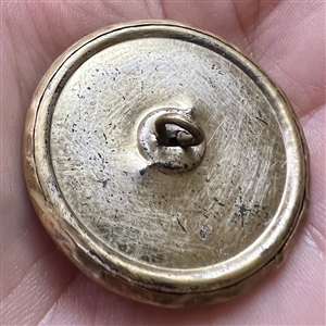 Brass openwork metal over darkened metal button.
