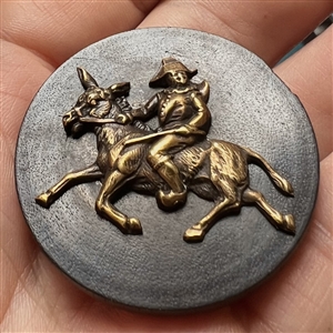 Wood button of Punchinello riding a donkey.