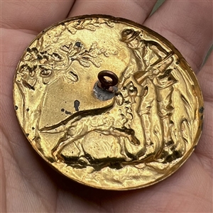 Stamped brass button of a hunter and his dog. 