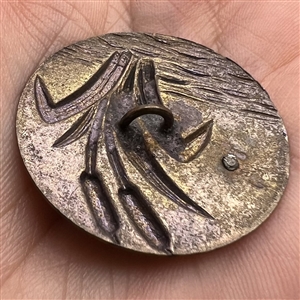 Stamped brass button of cattails and a flower.