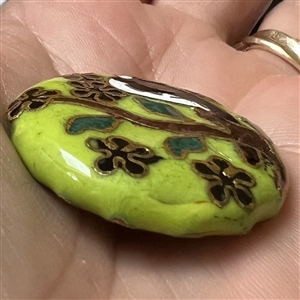Chinese cloisonné button of a bird in a flowering tree.