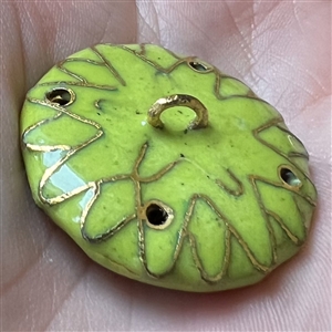 Chinese cloisonné button of a bird in a flowering tree.