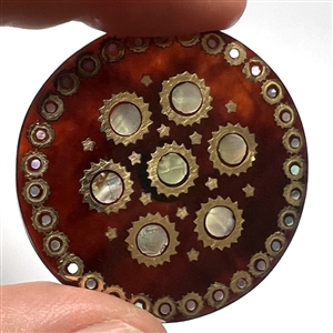 Translucent tortoise button with shell and metal inlay.