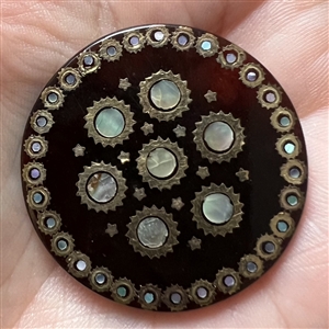 Translucent tortoise button with shell and metal inlay.