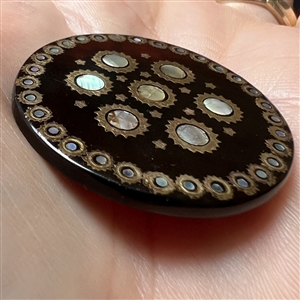 Translucent tortoise button with shell and metal inlay.