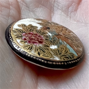 Satsuma button of a pheasant among Chrysanthemums.