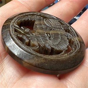Vintage casein button of a dragon.