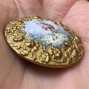 A 19th c. painted enamel button “Lady holding a sprig of flowers”