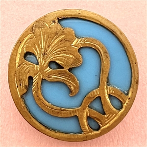 Turquoise glass set in brass button of an Art Nouveau iris.