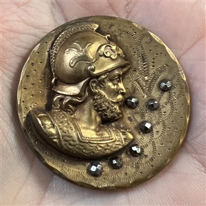 Large brass button of a head of a warrior.
