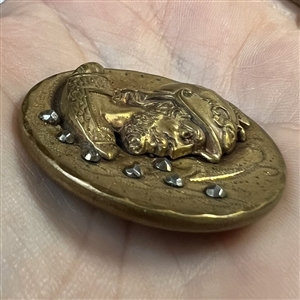 Large brass button of a head of a warrior.