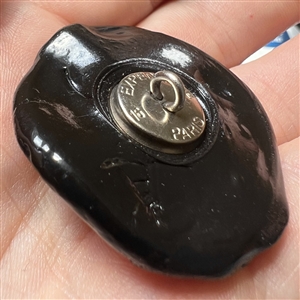 Resin button of man dressed as Santa playing an accordion.
