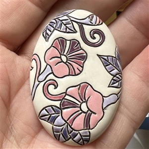 Oval ceramic button of morning glories by the Golem Studio.