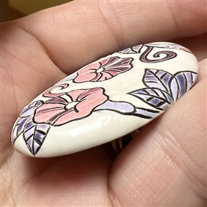 Oval ceramic button of morning glories by the Golem Studio.