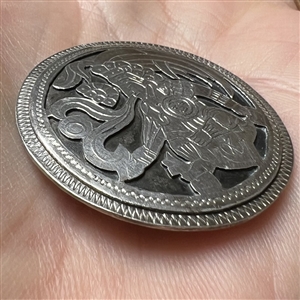 White metal button of Aztec god.