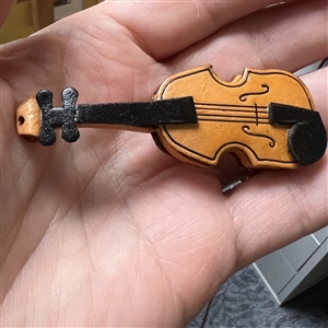 Large realistic violin leather button.