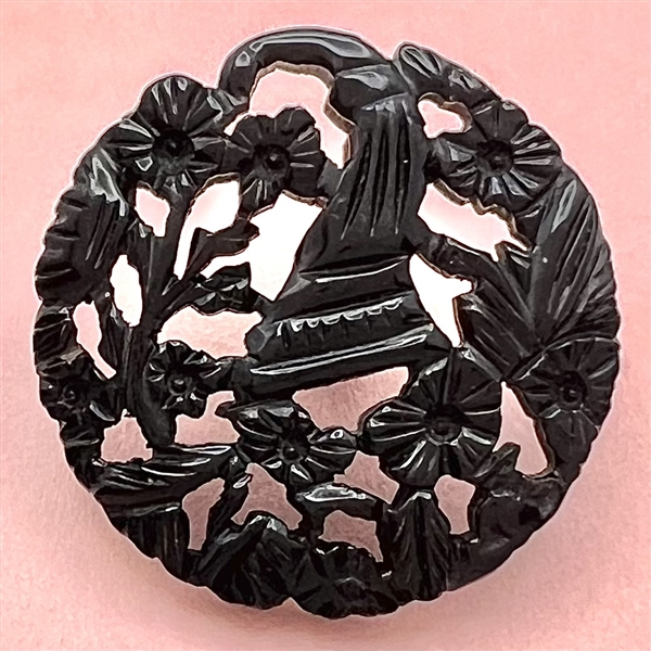 Casein button with open work of a cornucopia with flowers.