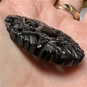 Casein button with open work of a cornucopia with flowers.