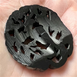 Casein button with open work of a cornucopia with flowers.