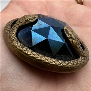 Large faceted iridescent lustered black glass with border of snakes