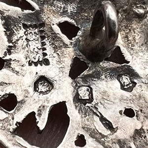 Hallmarked silver button with four snakes.