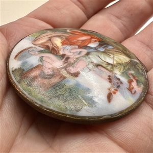 Porcelain button of women gossiping under a tree.