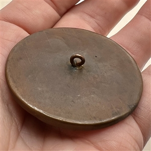 Porcelain button of women gossiping under a tree.