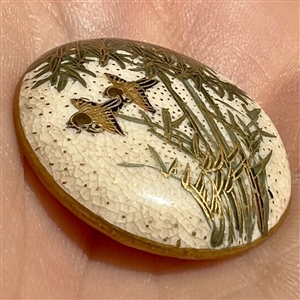 Satsuma button of two birds flying under bamboo.