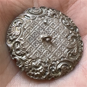 White metal “door knocker” button.
