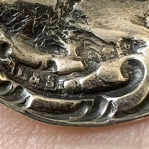 Hallmarked silver button of a courting couple.