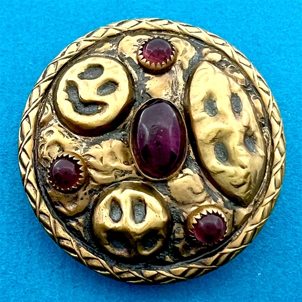 Arts and Crafts style brass button with amethyst glass.