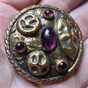 Arts and Crafts style brass button with amethyst glass.