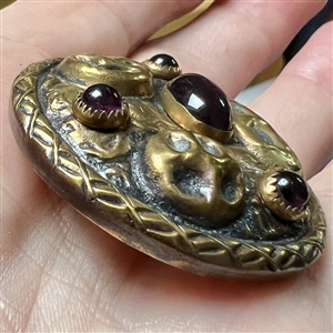 Arts and Crafts style brass button with amethyst glass.