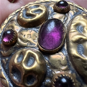 Arts and Crafts style brass button with amethyst glass.