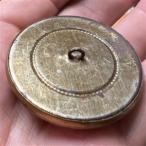 Arts and Crafts style brass button with amethyst glass.