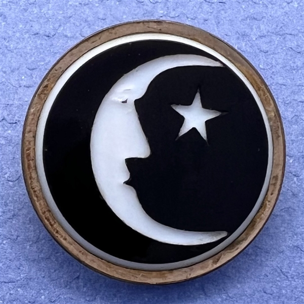 White & black glass “man in the moon” button. 