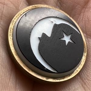 White & black glass “man in the moon” button. 