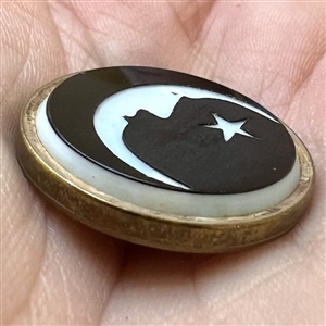 White & black glass “man in the moon” button. 